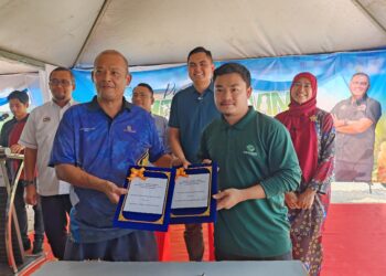 MUHAMAD Akmal Saleh menyaksikan upacara menandatangani perjanjian persefahaman (MoU) ladang kontrak antara Koperasi Komong Jasin Berhad dan Golden Corn Marketing Sdn. Bhd. sempena Sambutan Hari Ladang Peringkat Daerah Jasin di Kampung Rim, Jasin, Melaka hari ini. - UTUSAN/AMRAN ALI
