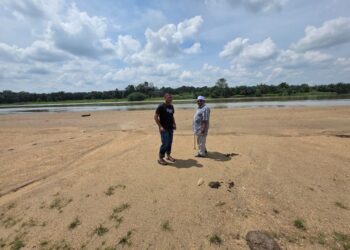 PENDUDUK berjalan di atas beting pasir yang timbul semasa air Sungai Perak surut di kawasan yang dikenali ‘padang koba’ di Teluk Bakong, Lambor Kanan dekat Parit, Perak semalam. – UTUSAN/AIN SAFRE BIDIN