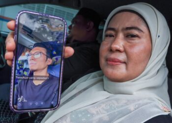 ZURAIDA Hashim menunjukkan gambar Muhammad Fakhrur Razi Usri ketika ditemui di Unit Perubatan Forensik HSJ, Pulau Pinang semalam. – UTUSAN/DANIAL SAAD