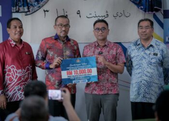 MUHAMMAD Fikri Abdul Aziz (dua, kanan) menyampaikan replika cek bernilai Rm10,000 kepada wakil KRT Putrajaya. -UTUSAN/FAIZ ALIF ZUBIR/PEMBERITA - HUSNI