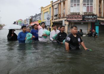 PENDUDUK di Taman Bendahara, Pengkalan Chepa, Kota Bharu, Kelantan mengharung banjir susulan hujan berterusan sejak kelmarin. – UTUSAN/BISMI KAMARUZAMAN