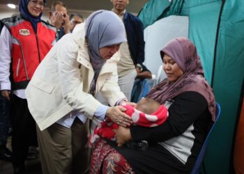 FADHLINA Sidek (kiri) menyantuni bayi yang berlindung di PPS SK Tapang, Kota Bharu, Kelantan hari ini-UTUSAN/KAMARUL BISMI KAMARUZAMAN.