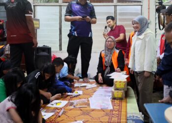 FADHLINA Sidek (kanan) meluangkan masa melihat kanak-kanak yang sedang melakukan aktiviti mewarna di PPS SK Tapang, Kota Bharu, Kelantan hari ini-UTUSAN/KAMARUL BISMI KAMARUZAMAN.