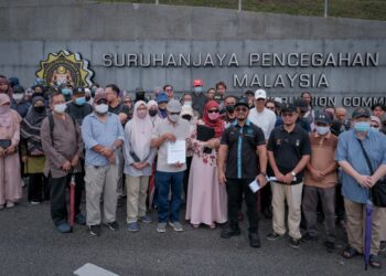 HISHAMUDDIN Hashim bersama sebahagian daripada 276 mangsa skim pelaburan yang mengalami kerugian lebih RM104 juta di pekarangan Ibu Pejabat SPRM, Putrajaya. - UTUSAN/FAIZ ALIF ZUBIR