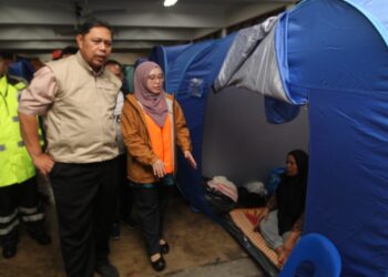 MEOR Ismail Meor Akim (kiri) semasa melawat mangsa banjir yang berlindung di PPS SK Sabak, Kota Bharu, Kelantan hari ini.