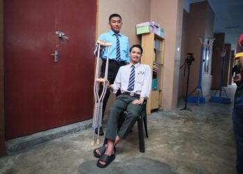 MOHD. Izham Ruzaini Zakaria (duduk) bersama rakan baiknya sebelum masuk ke dewan peperiksaan untuk menduduki SPM di SMK Sultan Ismail, Kota Bharu, Kelantan hari ini-UTUSAN/KAMARUL BISMI KAMARUZAMAN.