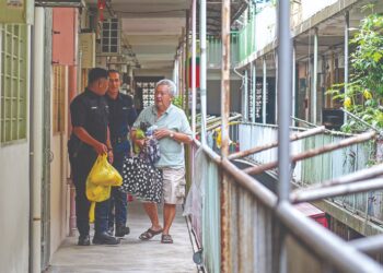 ANGGOTA polis membantu seorang penduduk untuk berpindah susulan kejadian tanah runtuh di Taman United, Seputeh, Kuala Lumpur. – UTUSAN/ISKANDAR ISHAK.