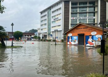 KEADAAN di hadapan Blok B HTF, masih digenangi air namun dapat dilalui kenderaan di Kangar, Perlis hari ini. -UTUSAN/ASYRAF MUHAMMAD