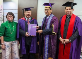 ABDUL Rahman Mohamed (dua dari kanan) mengucapkan tahniah kepada Dr. Ng Jet Kwan pada Upacara Konvokesyen Ke-63 USM di George Town, Pulau Pinang semalam.-UTUSAN/DANIAL SAAD