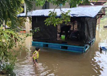 RUMAH rakit yang disumbangkan oleh badan bukan kerajaan dijadikan sebagai tempat penyimpanan barangan selepas kawasan Kampung Tersang, Rantau Panjang, Kelantan mula dinaiki air semalam.-UTUSAN/YATIMIN ABDULLAH.