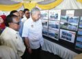 AHMAD Zahid Hamidi melihat gambar-gambar projek pembinaan jalan pada Majlis Perasmian Penyerahan Jalan Luar Bandar Kementerian Kemajuan Desa dan Wilayah.-UTUSAN/SHIDDIEQIIN ZON