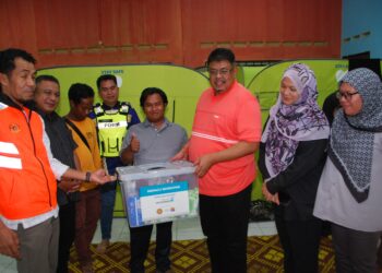 KETUA Menteri Melaka, Datuk Seri Ab. Rauf Yusoh menyampaikan kain selimut dan bantal di PPS Balai Raya Kampung Seri Jeram, Masjid Tanah, Melaka malam tadi. - UTUSAN/AMRAN MULUP