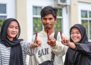 Pengundi muda (dari kiri) Siti Nuraisyah Jamil, 19, Norman Hakim Zafar, 20 dan Siti Jasnirah Jasnan, 19, menunaikan tanggungjawab mengundi di Pusat Mengundi Sekolah Kebangsaan Serusup, Tuaran, Sabah semalam. – MINGGUAN/AMIR KHALID