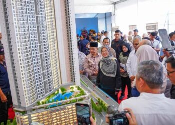 ZALIHA Mustafa melihat replika projek pembangunan semula Kampung Sungai Baru selepas majlis pecah tanah di Kampung Sungai Baru, Kuala Lumpur, hari ini. - UTUSAN/SADDAM YUSOFF