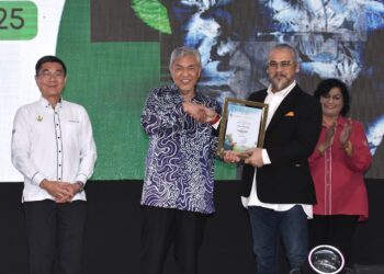 AHMAD Zahid Hamidi menyampaikan watikah pelantikan Duta Alam Sekitar kepada Awie pada Majlis Sambutan Hari Alam Sekitar Negara Peringkat Negeri Perak Tahun 2025 di Bagan Datuk hari ini. - UTUSAN/ZULFACHRI ZULKIFLI