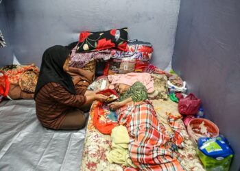 JAMALIAH Hashim menjaga ibunya, Yah Mahmud, 90, yang uzur ketika terpaksa menetap di PPS SK Seri Perdana ekoran rumah mereka di Kampung Titi Gajah dilanda banjir. - UTUSAN/ SHAHIR NOORDIN