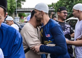 MOHAMMAD Adib (berbaju biru) berpelukan bersama ahli keluarga setelah dibebaskan selepas menjalani tahanan selama 13 bulan dan 20 hari di Kompleks Penjara Kajang di sini, hari ini. - UTUSAN/SYAKIR RADIN