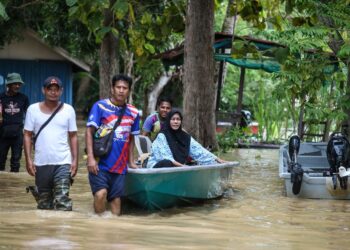 PENDUDUK kampung mengambil inisiatif membantu mengeluarkan mangsa yang terperangkap banjir menggunakan bot di Kampung Seberang Anak Bukit, Alor Setar hari ini. - UTUSAN/ SHAHIR NOORDIN