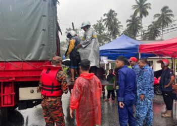 PASUKAN menyelamat membantu membawa keluar mangsa banjir yang terjejas di Kampung Wang Kelian, Padang Besar, Perlis. -UTUSAN/ASYRAF MUHAMMAD