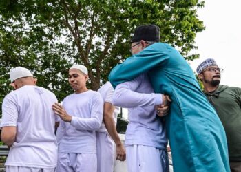 AHLI Global Ikhwan Services and Business Holdings Sdn Bhd (GISBH) berpelukan bersama ahli keluarga setelah dibebaskan selepas menjalani tahanan selama 13 bulan dan 20 hari di Kompleks Penjara Kajang di sini, hari ini. - UTUSAN/SYAKIR RADIN