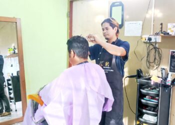 KHARIRUL Anwar Abd. Rahim  menawarkan khidmat menggunting rambut di kedai dan datang ke rumah pelanggan di sekitar Kuala Kangsar. - UTUSAN