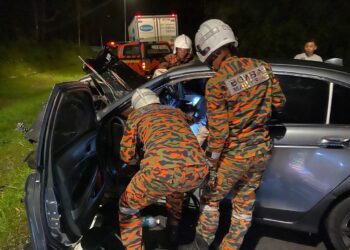 ANGGOTA bomba mengeluarkan pemandu kereta yang terlibat nahas dengan lori simen di Gerik hari ini.