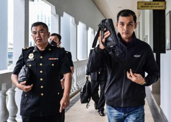 ANGGOTA polis, Che Mohamad Aswanee Che Ali yang didakwa atas dua pertuduhan menerima rasuah ketika tiba di Mahkamah Sesyen Kuala Lumpur di sini, hari ini. - UTUSAN/SYAKIR RADIN