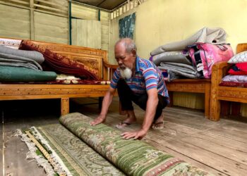 RAMLI Mohd. Akib mengemas dan memindahkan barangan kebahagian atas rumah sebagai persiapan menghadapi banjir di Kampung Air Taling Dangi, Johol, Kuala Pilah. – UTUSAN/NOR SHAFIQAH MOHD. GHAZALI