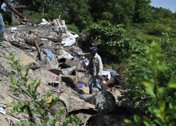 PENDUDUK menunjukkan lokasi sisa yang dipercayai bahan kimia dibuang di Taman Tronoh Baru dekat Batu Gajah.  - UTUSAN/LIYANA RAMLI