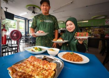 PAISAL Bakar dan Noorjannah Ariffin menunjukkan beberapa menu di warung mereka di Taman Putra Perdana, Puchong.
 – MINGGUAN/MUHAMAD IQBAL ROSLI