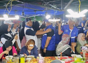 PERBEZAAN parti tidak menghalang dua calon iaitu Ma'mun Sulaiman yang mewakili Warisan bagi DUN Kukusan (dua dari kiri) dan Dr. Elmiariezan Ardan, calon BN DUN Apas bertegur apabila kedua-dua mereka bertembung semasa mengadakan walkabout di Pasar Malam Chester, Tawau, semalam.