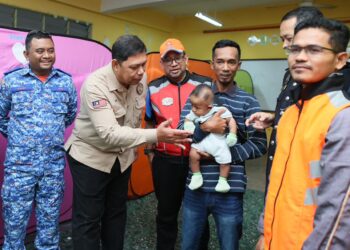 MEOR Ismail Meor Akim (dua kiri) menyantuni kanak-kanak yang berlindung di Sri Tumpat 2, Tumpat, Kelantan. - UTUSAN/KAMARUL BISMI KAMARUZAMAN