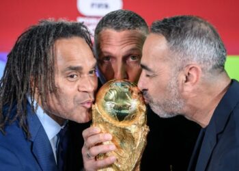 Bekas pemain Perancis, Christian Karembeu dan Youri Djorkaeff bersama bekas pemain Itali, Marco Materazzi mencium trofi Piala Dunia 2026 dalam majlis undian playoff di Zurich, semalam. - AFP