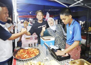 MA’MUN Sulaiman (kiri) bersalaman dengan para peniaga di pasar malam Chester, Tawau.