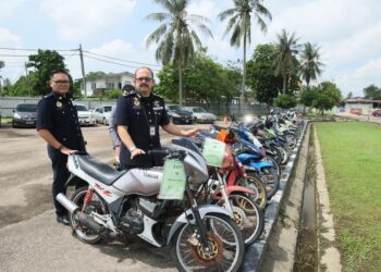 MOHD. Misuari Abdullah (kanan) menunjukkan dua buah motosikal Yamaha RXZ yang dilelong menerusi lelongan awam di Ibu Pejabat JPJ Kelantan di Panji, Kota Bharu, Kelantan. - UTUSAN/ KAMARUL BISMI KAMARUZAMAN