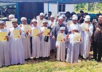 Pelajar Maahad Qiraat An Nur (MQAN), Bukit Puas, Jerantut menunjukkan sijil penyertaan belajar menternak ikan tilapia dalam tangki kanvas  di Maahad Qiraat An Nur Bukit Puas, Jerantut, Pahang baru-baru ini. – UTUSAN/HARIS FADILAH AHMAD.