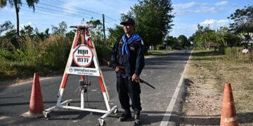 NARONGCHAI Putthet berdiri di sekatan jalan raya ketika di zon pemindahan di wilayah Buriram, Thailand.-AFP