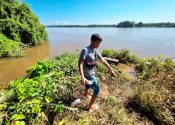PENDUDUK menunjukkan lokasi  seorang pemuda diserang buaya ketika menjala ikan di Kampung Sungai Buaya, Kampung Gajah di Pasir Salak, Perak.– UTUSAN/AIN SAFRE BIDIN