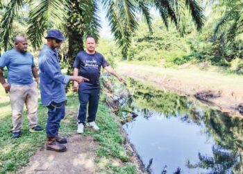 RAHIM Rohkim Iska (kanan) bersama penduduk menunjukkan air Sungai Serdang berwarna hitam mengalir ke kawasan tapak pelupusan sampah haram di Klang, Selangor.