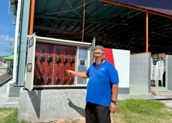JEFFERI Ahmad menunjukkan kotak meter elektrik yang tidak dipasang oleh pihak berwajib ketika ditemui di gerai makanan Taman Clonlee 
di Tampin, semalam. – UTUSAN / NOR SHAFIQAH MOHD. GHAZALI.