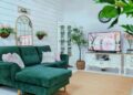 Ruang tamu dilatari rona neutral dengan sedikit sentuhan rona hijau pada sofa.