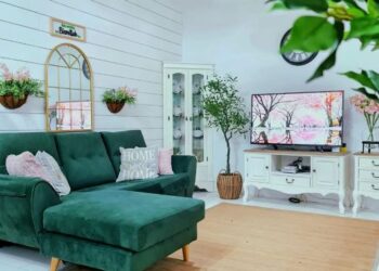 Ruang tamu dilatari rona neutral dengan sedikit sentuhan rona hijau pada sofa.
