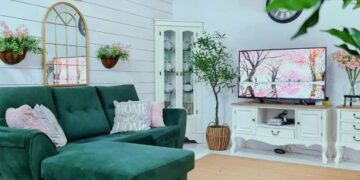 Ruang tamu dilatari rona neutral dengan sedikit sentuhan rona hijau pada sofa.