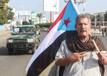 SEORANG lelaki memegang bendera Republik Rakyat Yemen Selatan pada ulang tahun ke-58 Hari Kemerdekaan Negara di bandar pelabuhan Aden, di bahagian selatan semenanjung Arab.- AFP