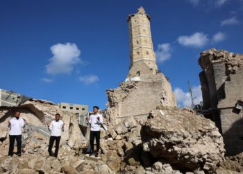 RAKYAT Palestin berdiri di tengah runtuhan bahagian Masjid Omari di Gaza City.- AFP