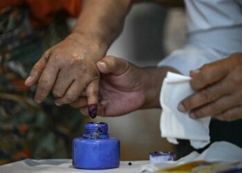 PENGUNDI mencelup jari di dalam dakwat selepas selesai mengundi dalam fasa pertama pilihan raya umum Myanmar di Yangon, semalam.- AFP