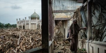 SEORANG pelajar berjalan di atas bangku untuk mengelak lumpur dan pokok tumbang di Sekolah Pondok Darul Mukhlisin di Aceh Tamiang, Sumatera Utara.-AFP