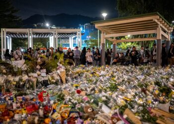ORANG ramai meletakkan bunga sebagai tanda penghormatan kepada mangsa kebakaran di luar Wang Fuk Court di daerah Tai Po, Hong Kong.-AFP