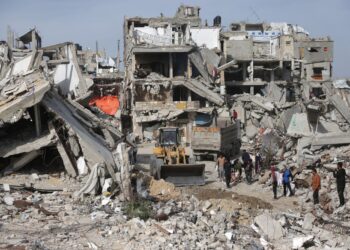 PENDUDUK Palestin membantu pekerja pembersihan menggunakan jentera berat untuk mengalihkan serpihan runtuhan bangunan di Khan Younis, Gaza. – AFP