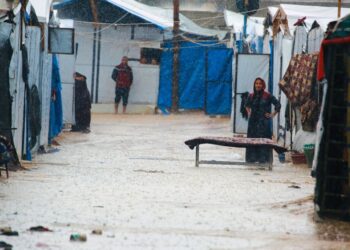 SEORANG wanita berdiri di dalam hujan bersebelahan khemah yang menempatkan penduduk Palestin di Deir al-Balah, tengah Gaza.- AFP